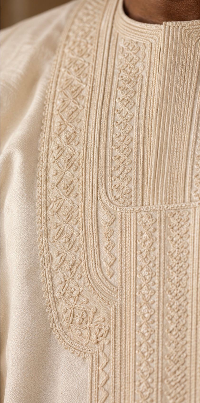 Close-up of tonal ivory embroidery and fabric texture.