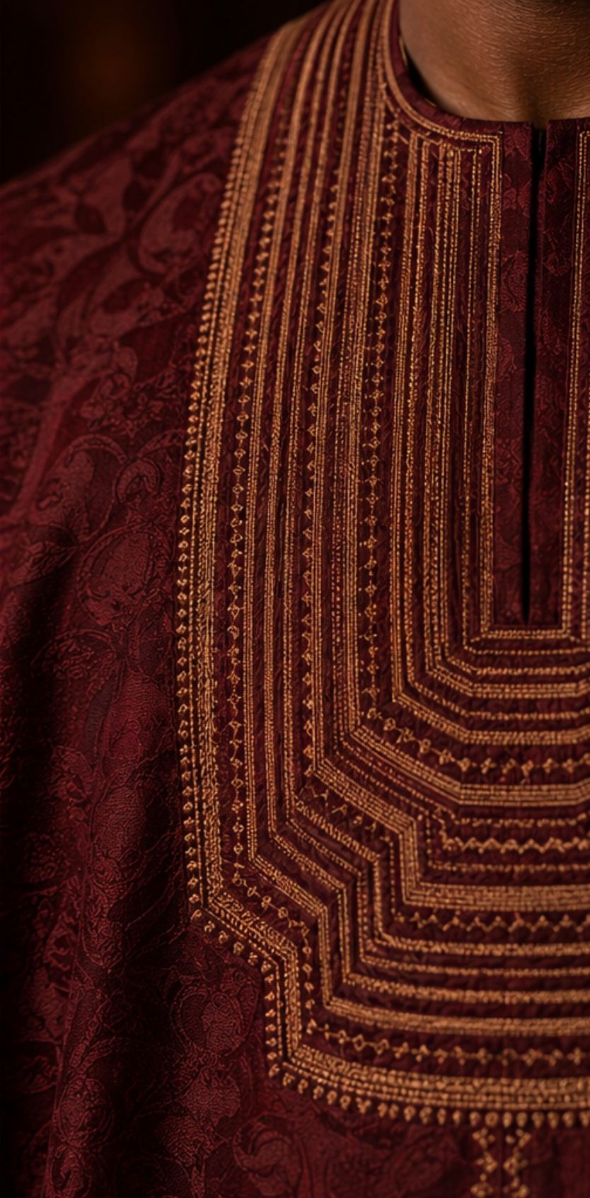 Close-up of bronze thread on deep oxblood fabric.